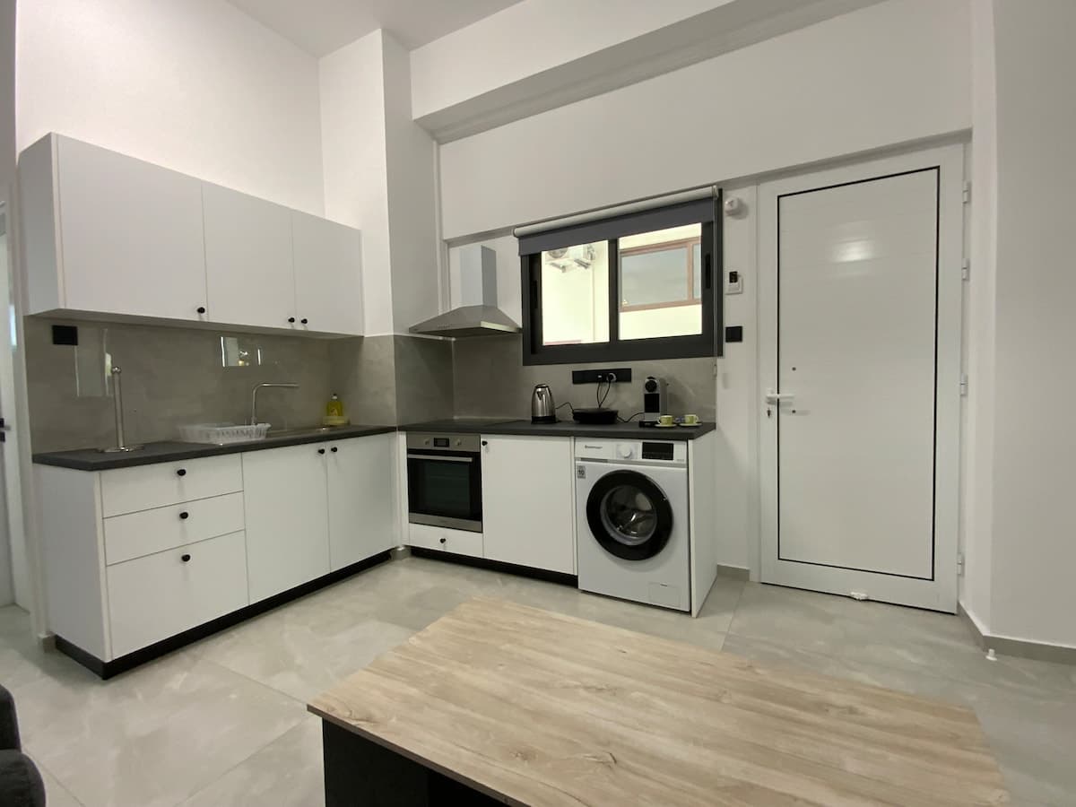Εσωτερική όψη της κουζίνας με φούρνο και πλυντήριο στο Niki Breeze